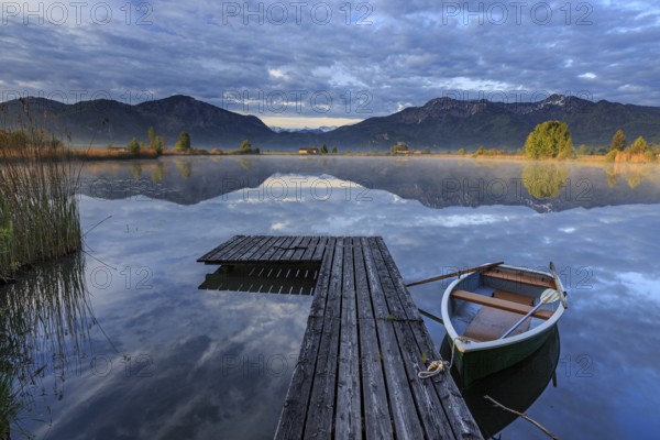 Mountains reflected in lake, jetty and boat, morning light, spring, Loisach-Lake Kochel moor, Bavaria, Germany, Europe