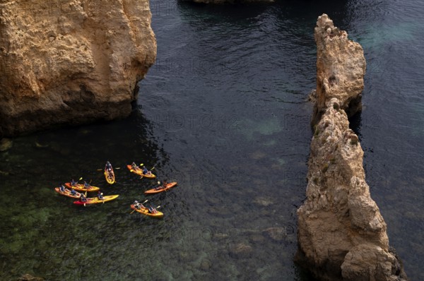 Kayaker, kayaks, kayaking, guided tour through grottos, rocks in the sea, Ponta da Piedade, Lagos, cliffs, Atlantic Ocean, Algarve, Portugal, Europe