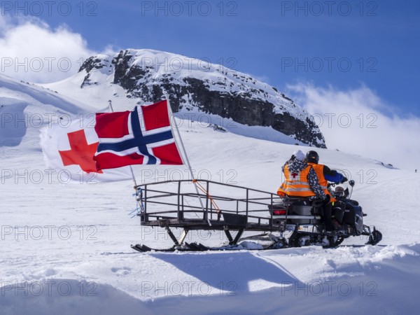 National day 17th May, snowscooter, norwegian flag, near Finse, glacier Hardangerjøkull, Hardanger, Norway, Europe