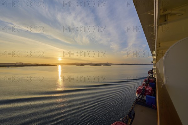 View from a cruise ship, Mein Schiff 6, of the calm sea at sunrise with soft clouds in the sky, Bergen, Vestland, Norway, Europe