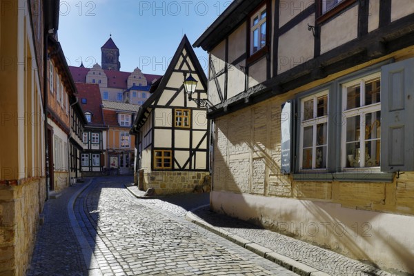 Half-timbered houses in Finkenherd with Schlossberg, alley in the old town centre of the World Heritage town of Quedlinburg, Saxony-Anhalt, Germany, Europe
