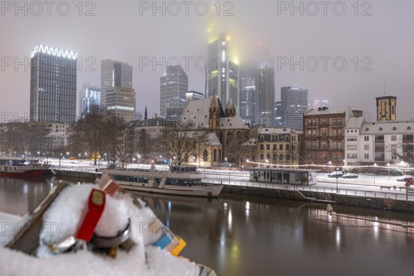 The skyscrapers of Frankfurt's banking skyline rise up from the snow-covered city centre into the low-hanging cloud cover. Frankfurt am Main, Hesse, Germany, Europe