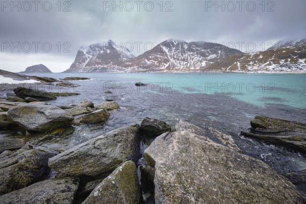 Rocky coast of fjord of Norwegian sea in winter with snow. Haukland beach, Lofoten islands, Norway, Europe