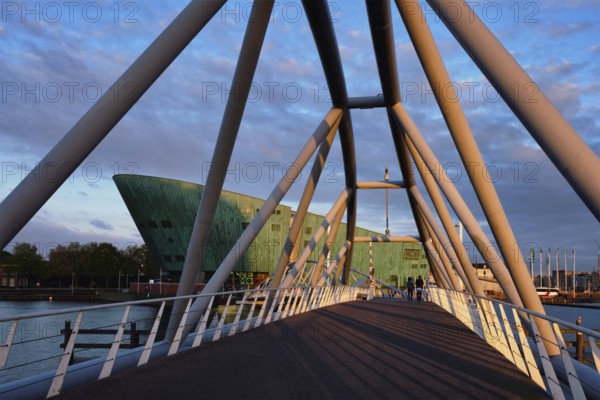 AMSTERDAM, NETHERLANDS, MAY 9, 2017: NEMO Science museum and Mr. J. van der Veldebrug bridge. It is the largest science center in Netherlands with over 500000 visitors per year