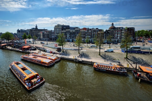AMSTERDAM, NETHERLANDS, MAY 9, 2017: Aerial view of Amsterdam canal with tourist boats near Amsterdam Centraal