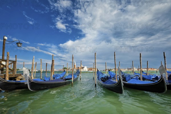 Gondolas and in lagoon of Venice by Saint Mark (San Marco) square with San Giorgio di Maggiore church in background in Venice, Italy, Europe
