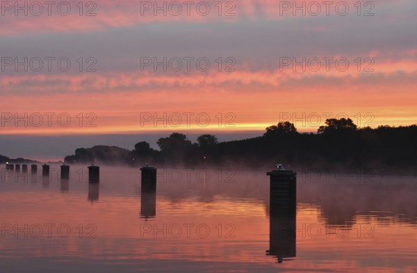 Jetty, dolphins, ship's switch at sunrise and fog on the Kiel Canal, Schleswig-Holstein, Germany, Europe