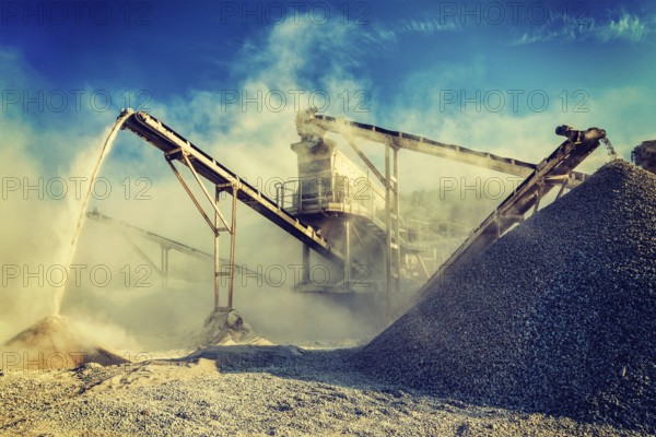 Vintage retro effect filtered hipster style image of Industrial background, crusher rock stone crushing machine at open pit mining and processing plant for crushed stone, sand and gravel