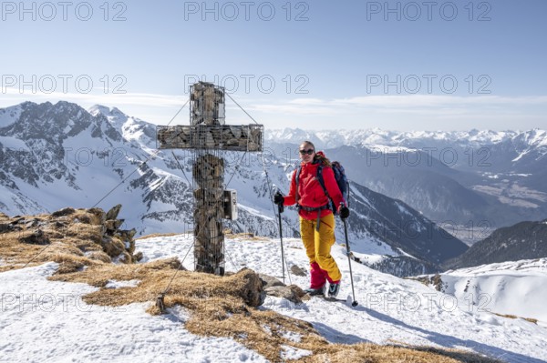 Ski tourers at the summit of the Mitterzeigerkogel with summit cross in winter, Sellraintal, Kühtai, Tyrol, Austria, Europe
