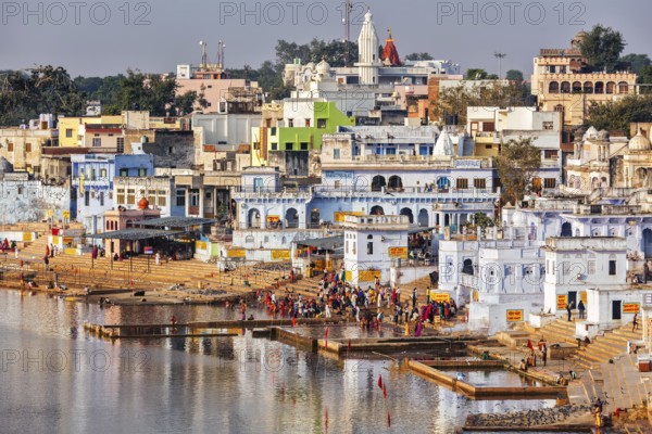 PUSHKAR, INDIA, NOVEMBER 20, 2012: Hindu devotees pilgrims bathing in sacred Puskhar lake (Sagar) on ghats of Pushkar, Rajasthan, India. Pushkar is holy city for Hinduists and famous for many Hindu temples