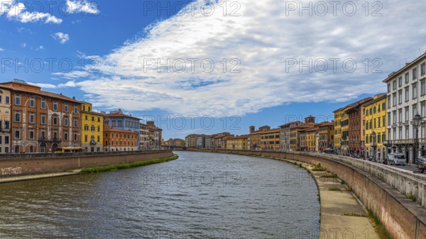 Rows of houses with pastel-coloured facades to the left and right of the River Arno, Pisa, Tuscany, Italy, Europe