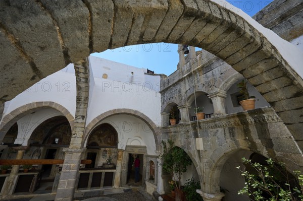 Historic courtyard with stone arches and white walls in a Mediterranean atmosphere, Agiou Theologou Monastery, St John's Monastery, Chora, Patmos, Dodecanese, Greek Islands, Greece, Europe