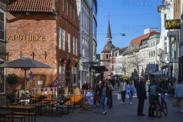 Oldenburg, Lower Saxony, Germany - Historic town centre, here the Lange Straße in the pedestrian zone, behind the Lappan, an old bell tower with a Renaissance dome, a sight in the old town of Oldenburg. The pedestrian zone is characterised by historic buildings, small alleyways, a variety of owner-managed shops and restaurants. On the left the Hof Apotheke
