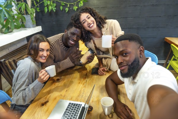 Diverse group of young people in a selfie time in a coworking space during coffee break