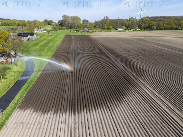 Artificial irrigation of a potato field in April, with a sprinkler system, long drought in spring makes this necessary, for the total of 7.5 hectares 3 full days are needed to get the necessary moisture for the freshly sown potato plants, south of Straelen, Lower Rhine, North Rhine-Westphalia, Germany, Europe