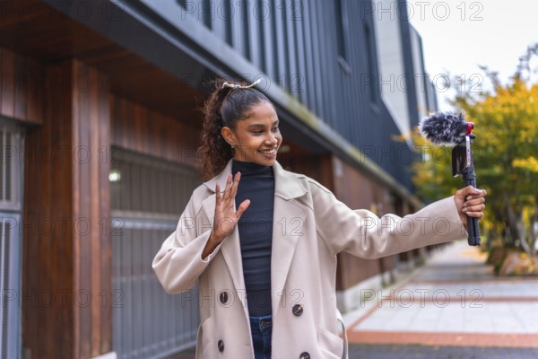 Afro beauty woman streaming online waving at camera outdoors in the city