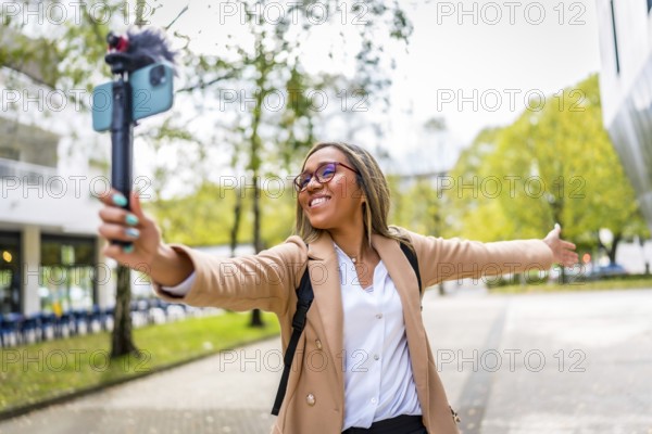 Latin female content creator opening arms showing a city to the audience while recording a video vlog