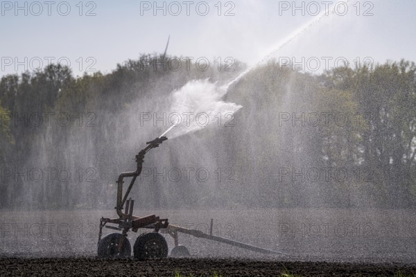 Artificial irrigation of a potato field in April, with a sprinkler system, long drought in spring makes this necessary, for the total of 7.5 hectares 3 full days are needed to get the necessary moisture for the freshly sown potato plants, south of Straelen, Lower Rhine, North Rhine-Westphalia, Germany, Europe