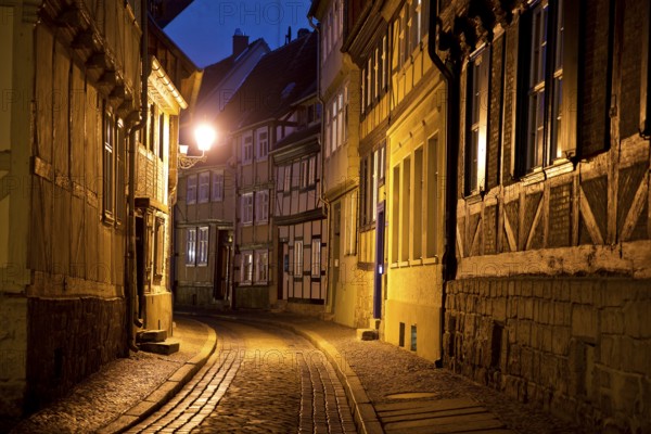 Half-timbered houses in a narrow street with cobblestones, Old Town in the evening, World Heritage City of Quedlinburg, Saxony-Anhalt, Germany, Europe