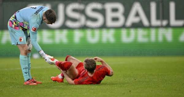 Fair play, goalkeeper Finn Dahmen FC Augsburg FCA (01) helps Harry Kane FC Bayern Munich FCB (09) to his feet after injury, in the background perimeter advertising FOOTBALL WWK Arena, Augsburg, Bavaria, Germany, Europe