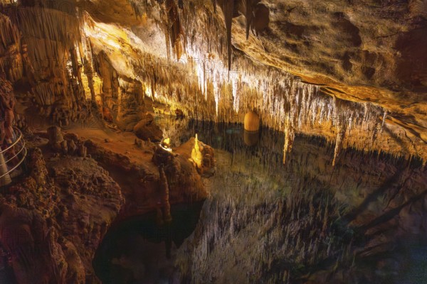 Beautiful stalactites reflecting on the martel lake in the caves of drach, mallorca, spain