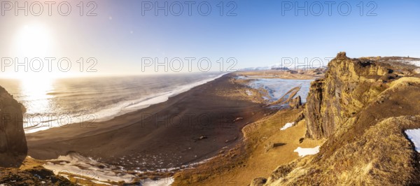 Panoramic view of Dyrholaey beach in cold winter with snow in Iceland, near Vik