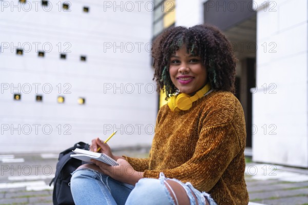 Portrait of black ethnic girl sitting in college doing classwork or studying for an exam on back to school