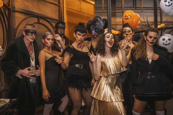 Halloween party with friends in a disco nightclub, group of friends sitting on a sofa in makeup and costumes