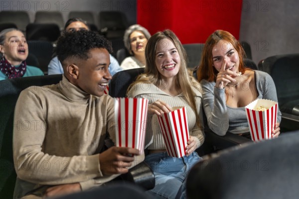Young people enjoying a movie at the cinema, sharing laughter and popcorn, creating memorable moments together in a relaxed atmosphere