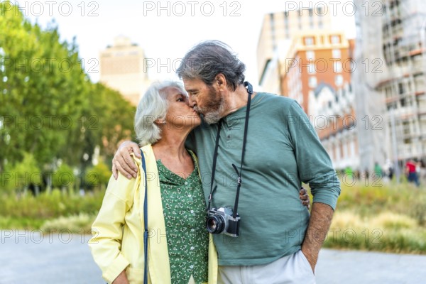 Frontal portrait of a senior couple kissing while visiting a city