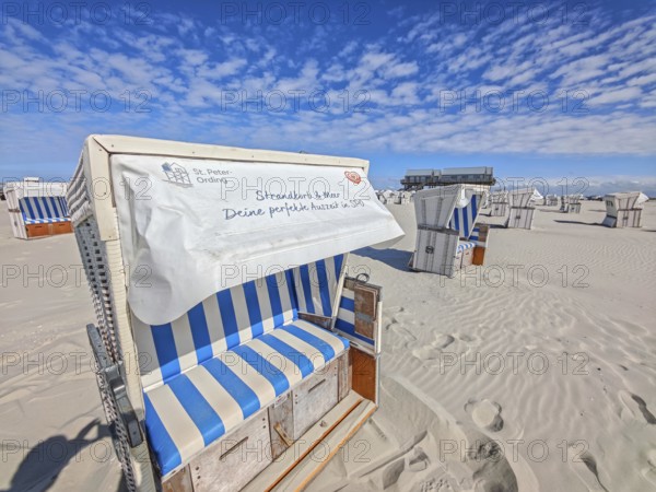 Preparing for the high season on the beach, setting up the beach chairs, North Sea, on the edge of the Wadden Sea National Park and UNESCO World Heritage Site, pile dwellings, sunshine and blue sky, SPO, Sankt Peter-Ording, Schleswig-Holstein, Germany, Europe