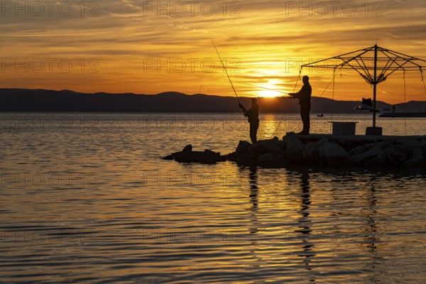 Anglers at sunset in Podgora, Croatia, Europe