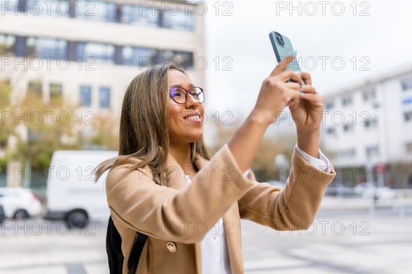 Latin female traveler taking photos of a city while walking along the street