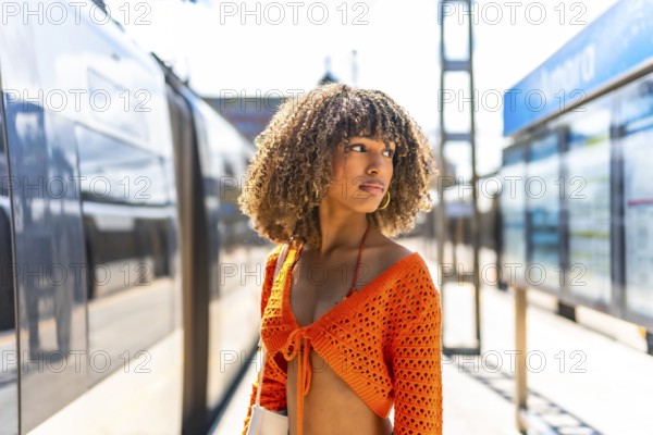 Latin beauty woman waiting for the train in the platform outdoors