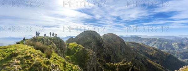 Group of hikers enjoying stunning views from the peak of aiako harria mountain in oiartzun, gipuzkoa, basque country, spain