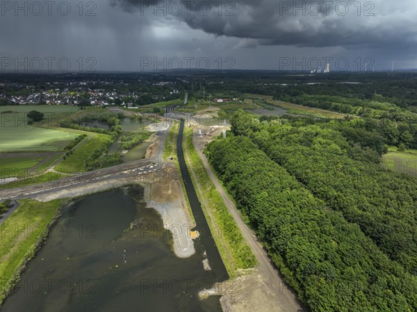 Dortmund / Castrop-Rauxel, North Rhine-Westphalia, Germany, river renaturalisation, renaturation of the Emscher, flood retention basin HRB Mengede. A new floodplain landscape is being created at the Emscher-Auen farm, expanding the area for flood protection during heavy rainfall and for biodiversity. The Emscher, which is currently straightened, will be given curves again and can meander through its new floodplain. Following the construction of a parallel sewer, the Emscher has been completely free of wastewater since 2022. The river was previously an open, above-ground mixed water channel with rainwater and wastewater. At the back right, the Uniper coal-fired power plant Datteln 4 power station, Europe
