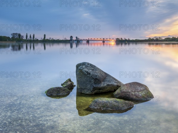 Sunrise at the historic lift bridge of Lindaunis over the Schlei, boulders in the water, Holstein Switzerland, Schleswig-Holstein, Germany, Europe