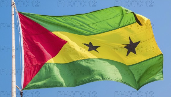 The flag of the Democratic Republic of Sao Tome, Africa, flutters in the wind, isolated against a blue sky