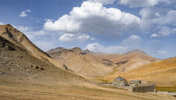Historic caravanserai Tash Rabat from the 15th century, with yellow hills, Atbashy district in the Naryn region, Kyrgyzstan, Asia