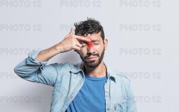 Young man with pain touching nose. A person with nasal bridge pain, Man with nasal bridge headache. Sinus pain concept
