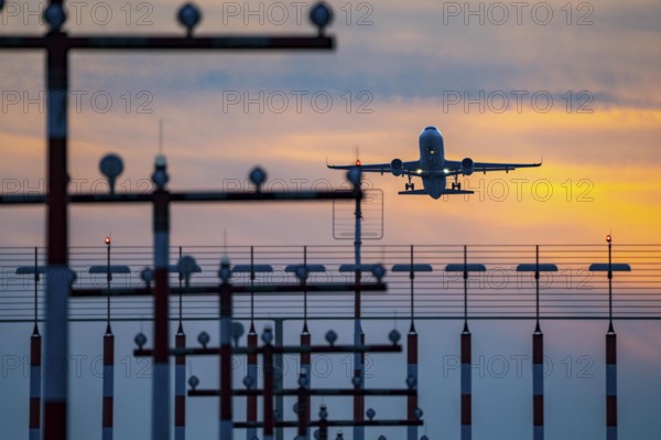 Runway lighting, approach aids, at Düsseldorf International Airport, sunset, aircraft taking off from the main runway south, 05R/23L, North Rhine-Westphalia, Germany, Europe