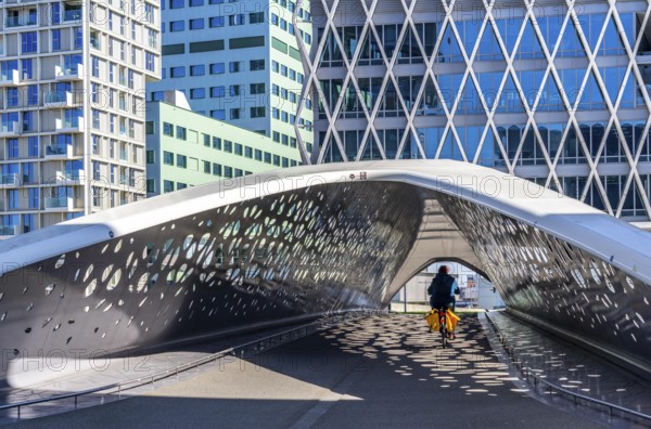 The Parkbruk, cycle and pedestrian bridge in the city centre of Antwerp, crosses a multi-lane city centre road, with tram lines, and thus connects two lively city districts Kop Spoor Noord and Eilandje, light effects by the sun, on the roadway, Belgium, Europe