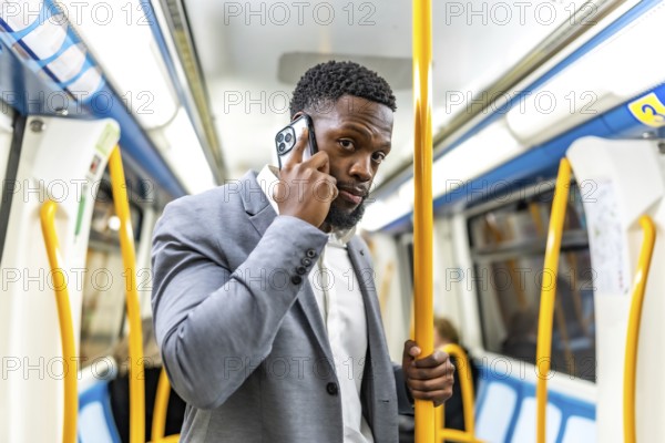 Young businessman commuting on public transport, using smartphone to stay connected while navigating the busy urban environment