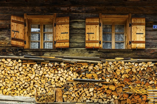 Old windows with shutters on an old farmhouse, firewood piled up in front, mountain village of Ayer, Val d'Anniviers, Valais Alps, Canton Valais, Switzerland, Europe