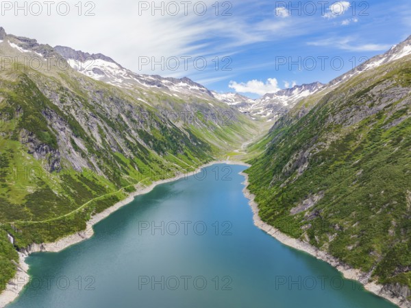 Mountain landscape with a blue lake in the centre, surrounded by lush greenery and snow-capped peaks under a clear sky, Klein Tibet, Zillertal, Austria, Europe