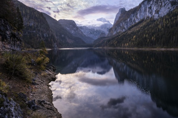 The Vordere Gosausee lake in the morning in autumn with a view of the Dachstein mountain range. The Gosaukamm on the right. Cloudy and blue sky. Reflection. Vorderer Gosausee, Gosau, Gosau valley, Salzkammergut, Upper Austria, Austria, Europe