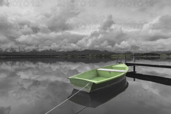 Storm clouds at sunset, a green rowing boat lashed to the wooden jetty, Hopfensee, Hopfen am See, near Füssen, Ostallgäu, Allgäu, Bavaria, Germany, Europe