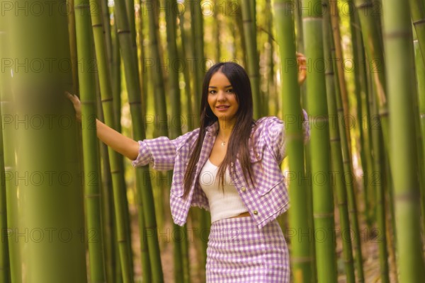 Young caucasian girl with a pink skirt in a bamboo forest. Enjoying the city on summer vacation in a tropical climate, a girl lifestyle walking and smiling in the forest