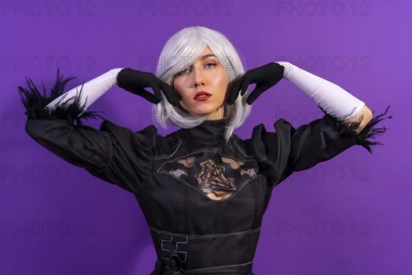Portrait of cosplay woman in a black costume and a white wig in studio on a purple background