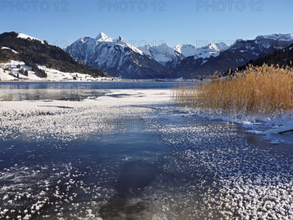 Frozen Sihlsee, reservoir, behind the snow-covered mountains Flübrig and Druesberg, Euthal, Canton Schwyz, Switzerland, Europe